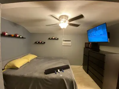 a bedroom with a ceiling fan and a television at Cozy House in Fort Lauderdale