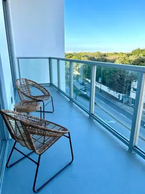 a balcony with two chairs and a view of a street at Sleek 2BD 2BA Condo In Miami Design District in Miami