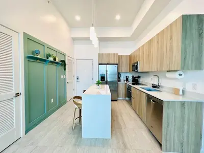 a kitchen with green cabinets and a white counter top at Sleek 2BD 2BA Condo In Miami Design District in Miami