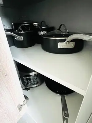 a shelf with pots and pans on top at Sleek 2BD 2BA Condo In Miami Design District in Miami