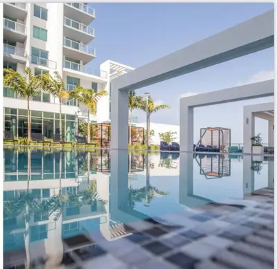 a reflection of a building and a basketball hoop in a pool at Sleek 2BD 2BA Condo In Miami Design District in Miami