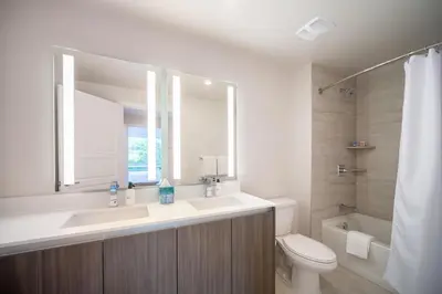 a bathroom with a sink and a toilet and a mirror at Tucker at Palmer Dadeland Miami in Miami