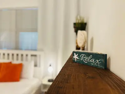 a table with a sign that says relax in a living room at CocoBay 2BR Condos Near Beach, Galleria Mall, Wilton Manors, Cruise Port in Fort Lauderdale