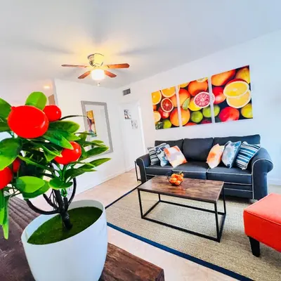 a living room with a couch and a plant at CocoBay 2BR Condos Near Beach, Galleria Mall, Wilton Manors, Cruise Port in Fort Lauderdale