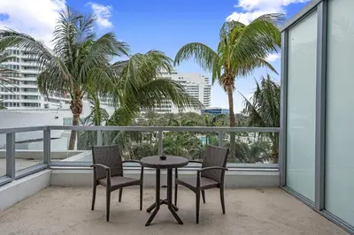a balcony with a table and chairs and palm trees at Junior Suite 2 at Sorrento Residences- Miami Beach home in Miami Beach