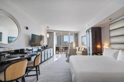 a hotel room with a bed and a mirror at Junior Suite 2 at Sorrento Residences- Miami Beach home in Miami Beach