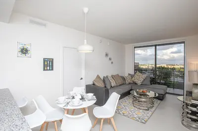 a living room with a couch and a table and chairs at Luxury 1BD/1BT Apartment in Downtown Doral in Miami