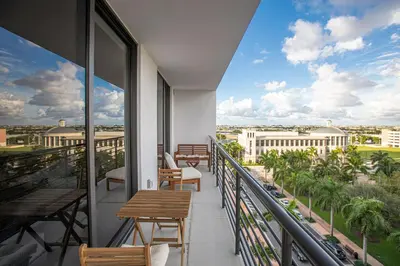 a balcony with tables and chairs and a view of the city at Luxury 1BD/1BT Apartment in Downtown Doral in Miami
