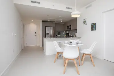 a kitchen and dining room with a table and chairs at Luxury 1BD/1BT Apartment in Downtown Doral in Miami