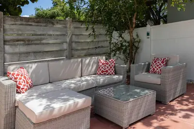 a patio with wicker chairs and a couch and a table at Beautiful Casita with King Bed and private patio Close to Calle 8, MIA Airport, Coral Gables in Miami