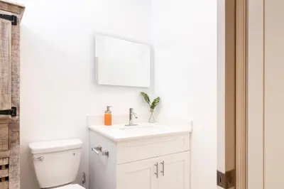 a white bathroom with a sink and a toilet at Beautiful Casita with King Bed and private patio Close to Calle 8, MIA Airport, Coral Gables in Miami