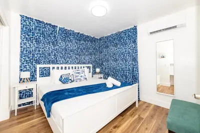 a bedroom with blue tiled walls and a bed at South Beach Apartments in Miami Beach
