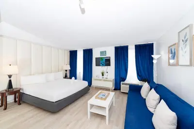 a bedroom with a white bed and blue curtains at South Beach Apartments in Miami Beach