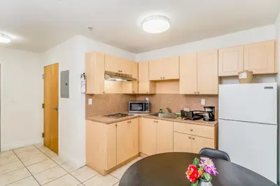 a kitchen with a table and a white refrigerator at South River Suites in Medley