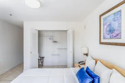 a bedroom with a white bed and blue pillows at South River Suites in Medley