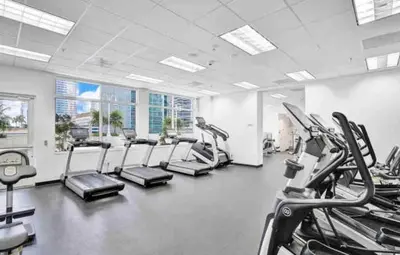 a gym with rows of treadmills and cardio machines at Luxurious Condo with PARKING in Brickell Miami in Miami