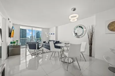 a white living room with a table and chairs at Luxurious Condo with PARKING in Brickell Miami in Miami