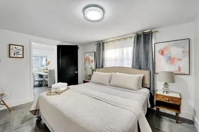 a white bedroom with a large bed and a window at Casa Del Sol in Hollywood