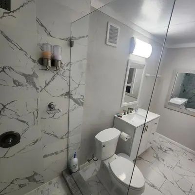 a bathroom with a toilet and a glass shower at Private and beautiful room for vacation in Carver Ranches