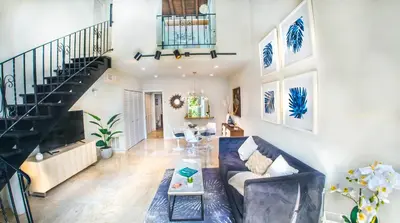 a living room with a couch and a staircase at Villas at St James Place UNIT F, Luxury, Pet Friendly in Miami