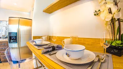 a kitchen with a table with dishes and a refrigerator at Villas at St James Place UNIT F, Luxury, Pet Friendly in Miami
