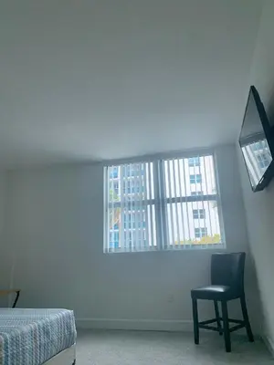 a bedroom with a chair and a window at Great private room in Miami Beach