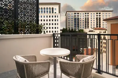 a table and chairs on a balcony with a view at Loews Coral Gables Hotel in Miami