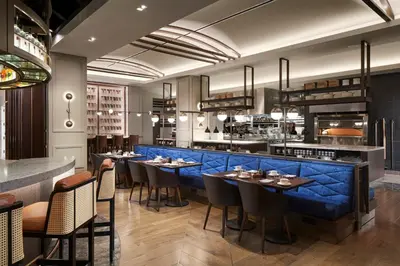 a restaurant with a blue bar with tables and chairs at Loews Coral Gables Hotel in Miami