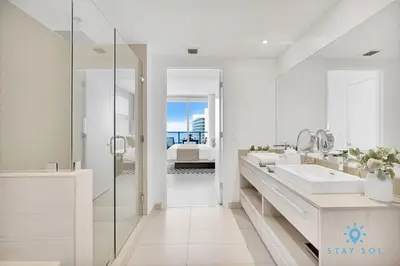 a white bathroom with two sinks and a shower at Oceanfront Balcony - Amazing Pools - Gym in Hollywood