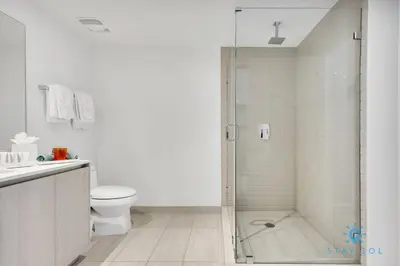a white bathroom with a shower and a toilet at Oceanfront Balcony - Amazing Pools - Gym in Hollywood