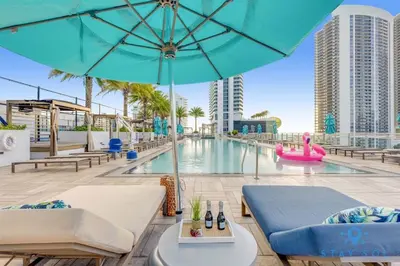 a pool with chairs and an umbrella and a pool at Oceanfront Balcony - Amazing Pools - Gym in Hollywood