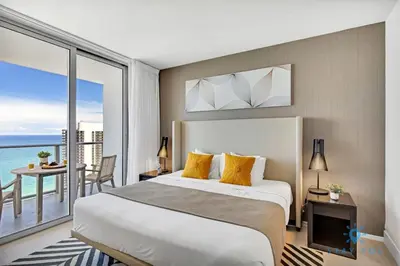 a bedroom with a large bed and a balcony at Oceanfront View - Balcony - Hot Tub - Gym in Hollywood