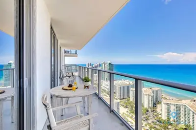 a balcony with a table and chairs and the ocean at Exclusive Condo - Near Beach - Free Valet Parking in Hollywood
