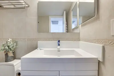 a bathroom with a white sink and a mirror at Sunny Isles Beach Retreat with Resort Perks! in Miami Beach