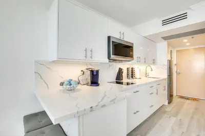 a white kitchen with white cabinets and a counter top at Sunny Isles Beach Retreat with Resort Perks! in Miami Beach