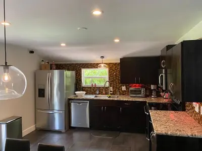 a kitchen with black cabinets and a stainless steel refrigerator at HEART OF WILTON MANORS in Fort Lauderdale