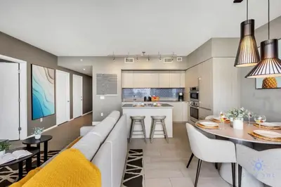 a living room and kitchen with a couch and a table at Amazing Pools - Near Beach - Parking Included in Hollywood