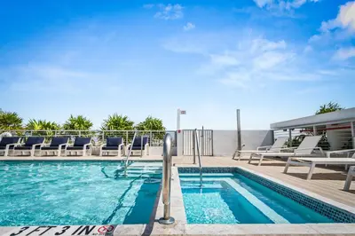a swimming pool with lounge chairs next to a building at Bay Harbor One Vacation in Miami Beach