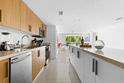 a kitchen with white counter tops and wooden cabinets at Bay Harbor One Vacation in Miami Beach