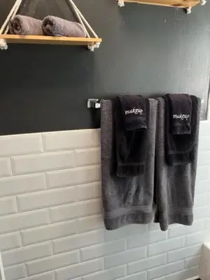 a bathroom with black towels hanging on a wall at Modern Spanish Villa- Pool- By River-Tropical !!! in Fort Lauderdale