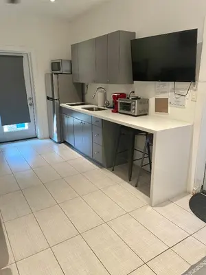 a kitchen with a counter with a sink and a microwave at Modern Riverview Apartments in Fort Lauderdale