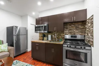 a kitchen with a stove and a stainless steel refrigerator at The Pearl Beachside Apartments on Hollywood Beach in Hollywood