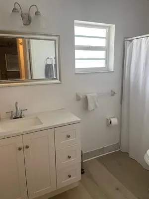 a bathroom with a sink and a mirror and a shower at Cozy Downtown Apartments on Water in Fort Lauderdale