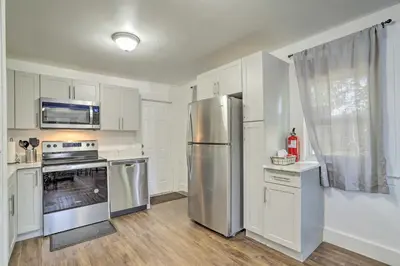 a kitchen with white cabinets and a stainless steel refrigerator at Beautiful Miami Getaway Less Than 6 Mi to Downtown! in Miami