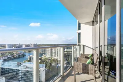 a balcony with a chair and a view of a city at Insane Ocean View Balcony - Beachfront Resort - Pools in Hollywood