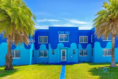 a blue building with palm trees in front of it at Free Parking - Bay View - Pool - Step To Beach in Hollywood