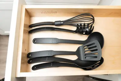 a wooden drawer with some utensils in it at The Hideaway at Lake Ridge 3 in Fort Lauderdale