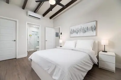 a white bedroom with a large white bed and a window at The Hideaway at Lake Ridge 1 in Fort Lauderdale