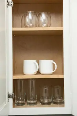 a cupboard with two cups and two mugs and glasses at The Hideaway at Lake Ridge 2 in Fort Lauderdale