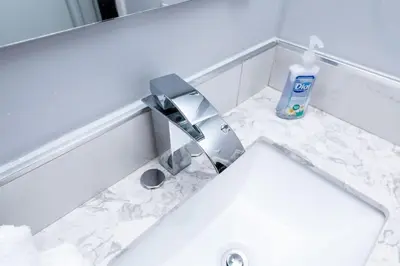 a bathroom sink with a faucet and a bottle of soap at The Palms at Middle River Terrace 3 in Fort Lauderdale